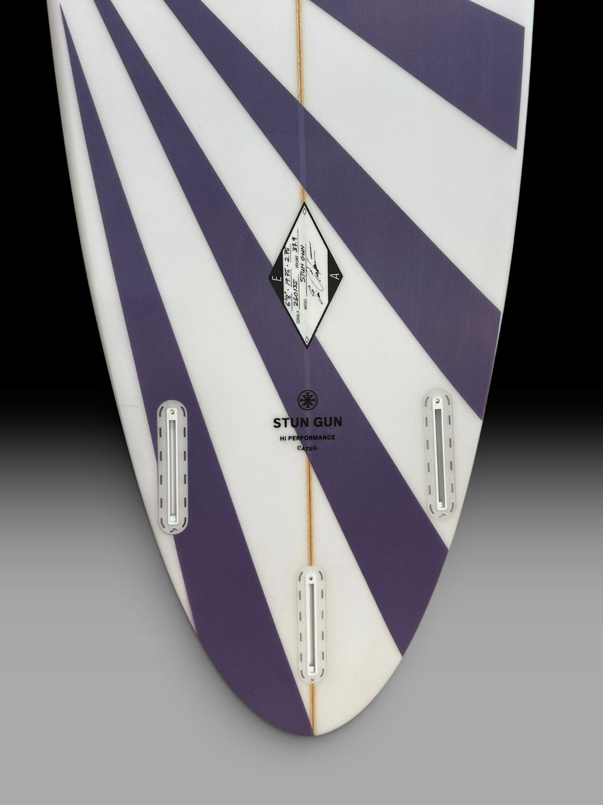 Arakawa Stun Gun 6'8 surfboard – tail and fin boxes close-up, purple sunburst spray