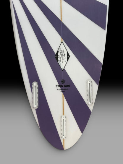 Arakawa Stun Gun 6'8 surfboard – tail and fin boxes close-up, purple sunburst spray